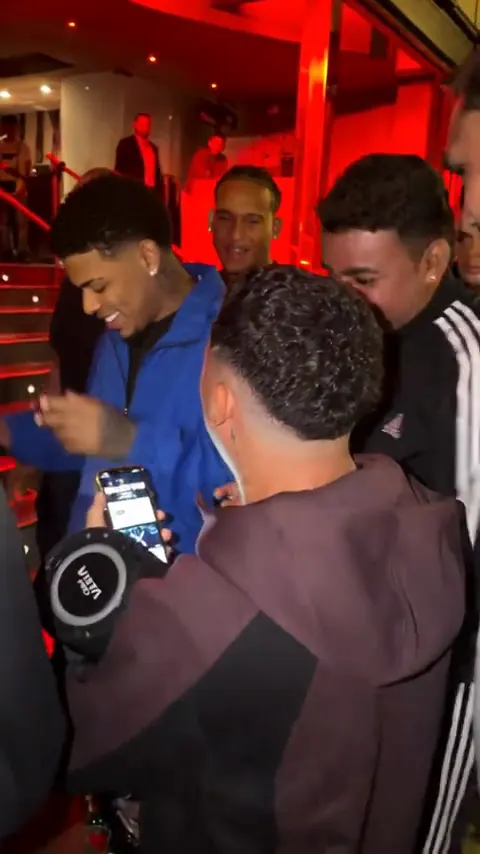 The rapper grins widely among the crowd, his friend’s phone still filming